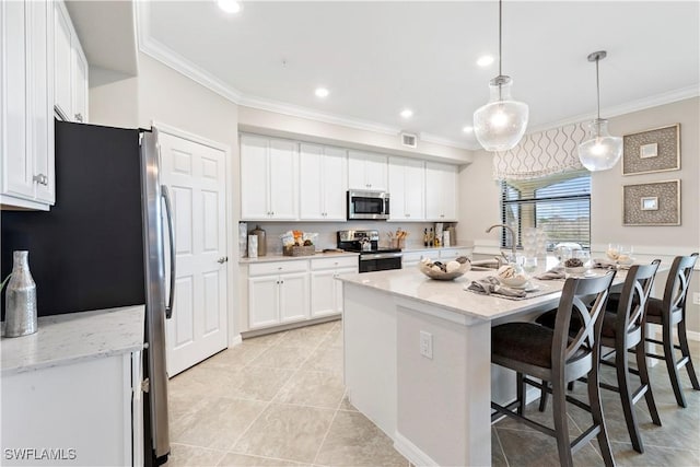 14826 Birchwood Ct Unit 6711, Punta Gorda, FL 33955 - kitchen with stainless steel appliances, crown molding, white cabinets, a breakfast bar area, and a kitchen island with sink
