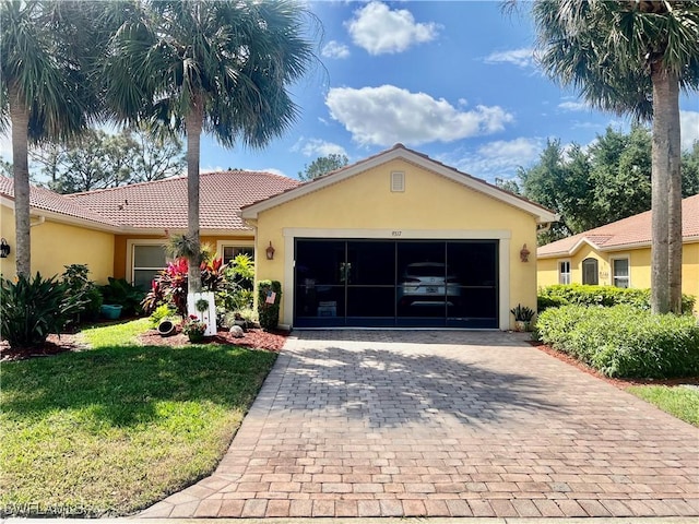 9317 Aegean Cir, Lehigh Acres, FL 33936 - ranch-style house featuring stucco siding, decorative driveway, and a front lawn