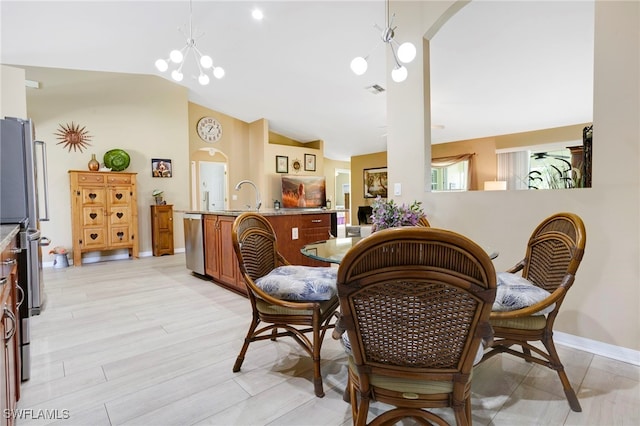 516 SE 14th Ter, Cape Coral, FL 33990 - dining area with a chandelier, lofted ceiling, arched walkways, and baseboards