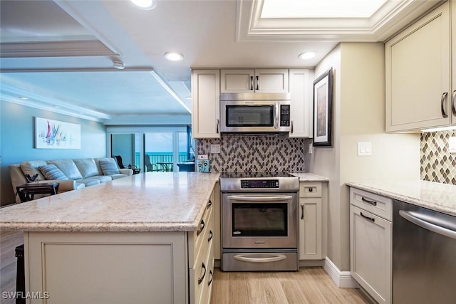 3443 Gulf Shore Blvd N Unit 409, Naples, FL 34103 - kitchen featuring appliances with stainless steel finishes, a peninsula, light wood-type flooring, recessed lighting, and ornamental molding