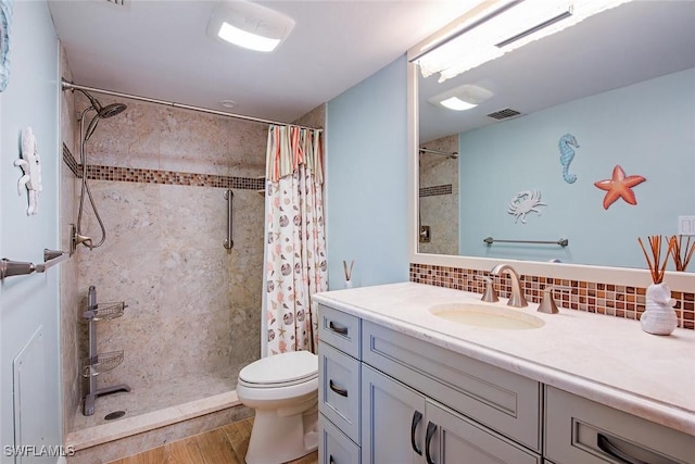 3443 Gulf Shore Blvd N Unit 409, Naples, FL 34103 - bathroom with toilet, vanity, tasteful backsplash, and a tile shower