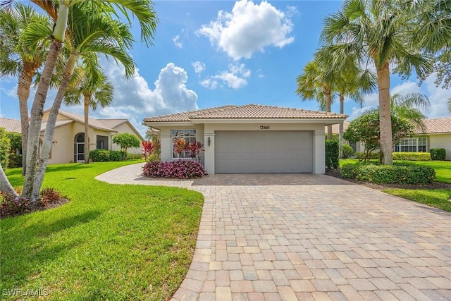 13461 Bridgeford Ave, Bonita Springs, FL 34135 - mediterranean / spanish house featuring stucco siding, an attached garage, a front lawn, decorative driveway, and a tile roof