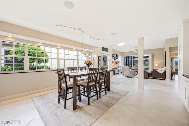 13461 Bridgeford Ave, Bonita Springs, FL 34135 - dining space with ornate columns, light tile patterned floors, healthy amount of natural light, and baseboards