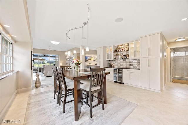 13461 Bridgeford Ave, Bonita Springs, FL 34135 - dining space with bar area, wine cooler, baseboards, and light tile patterned floors