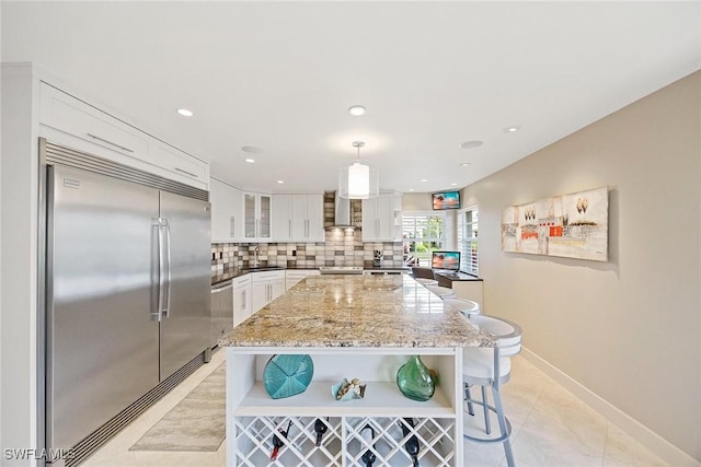 13461 Bridgeford Ave, Bonita Springs, FL 34135 - kitchen featuring appliances with stainless steel finishes, open shelves, white cabinetry, wall chimney range hood, and tasteful backsplash