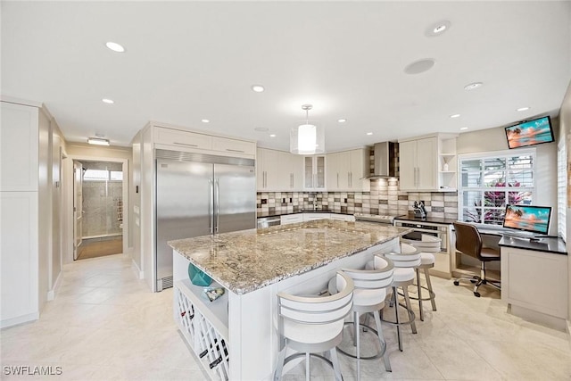 13461 Bridgeford Ave, Bonita Springs, FL 34135 - kitchen with open shelves, stainless steel appliances, wall chimney range hood, a kitchen island, and recessed lighting