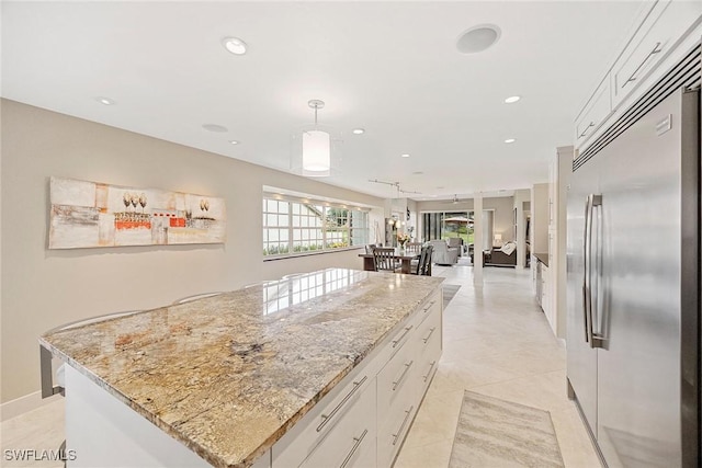 13461 Bridgeford Ave, Bonita Springs, FL 34135 - kitchen featuring stainless steel built in fridge, a kitchen island, white cabinetry, light stone counters, and recessed lighting