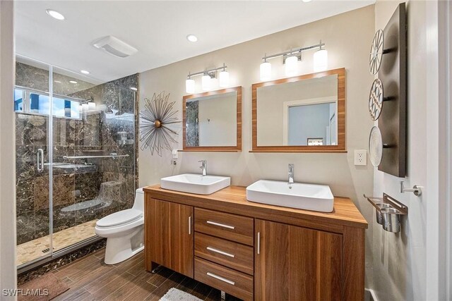 13461 Bridgeford Ave, Bonita Springs, FL 34135 - full bath with double vanity, toilet, a shower stall, wood finished floors, and recessed lighting