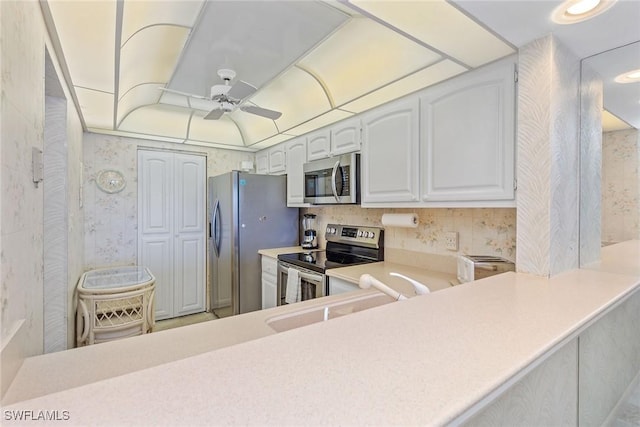 591 Seaview Ct Unit A306, Marco Island, FL 34145 - kitchen featuring stainless steel appliances, ceiling fan, a sink, light countertops, and wallpapered walls