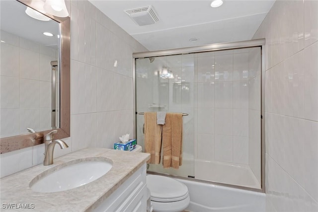 591 Seaview Ct Unit A306, Marco Island, FL 34145 - full bath featuring tile walls, vanity, toilet, and bath / shower combo with glass door