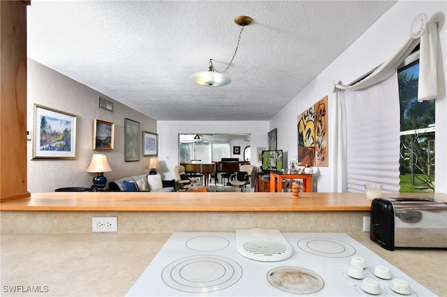 2212 E 6th St, Lehigh Acres, FL 33936 - kitchen with a textured ceiling, white electric cooktop, and light countertops
