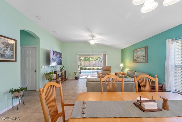 15721 Beachcomber Ave, Fort Myers, FL 33908 - tiled dining room featuring arched walkways, a ceiling fan, vaulted ceiling, and baseboards