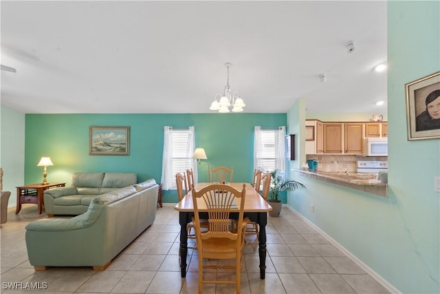 15721 Beachcomber Ave, Fort Myers, FL 33908 - dining space featuring a chandelier, light tile patterned floors, and baseboards
