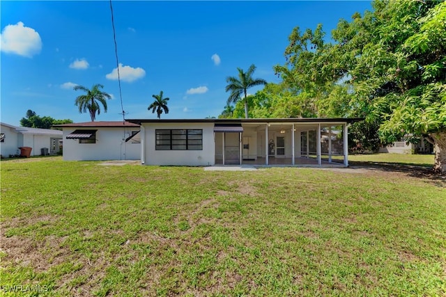 4101 Rainbow Dr, Fort Myers, FL 33916 - back of house with a yard, a sunroom, and stucco siding