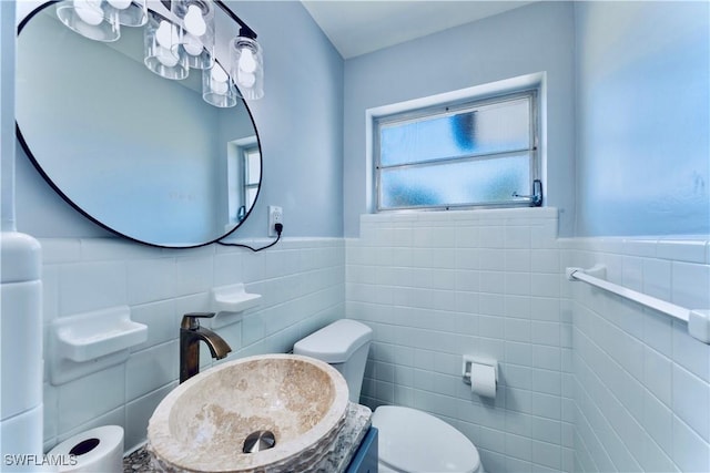 4101 Rainbow Dr, Fort Myers, FL 33916 - bathroom featuring tile walls, a sink, toilet, and wainscoting