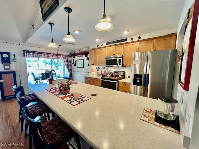 40 Ortona St, Lehigh Acres, FL 33936 - kitchen featuring stainless steel appliances, a sink, a breakfast bar area, and hanging light fixtures