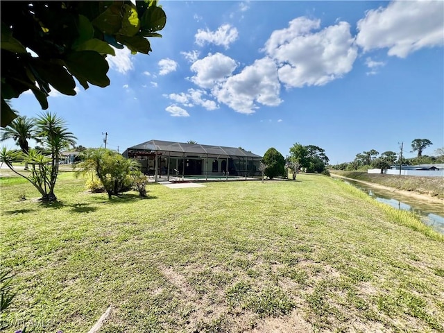40 Ortona St, Lehigh Acres, FL 33936 - view of green lawn with a swimming pool, glass enclosure, and a water view