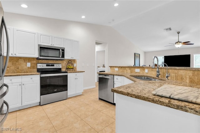 1402 Congress Ave, Lehigh Acres, FL 33972 - kitchen with appliances with stainless steel finishes, a sink, vaulted ceiling, decorative backsplash, and light stone countertops