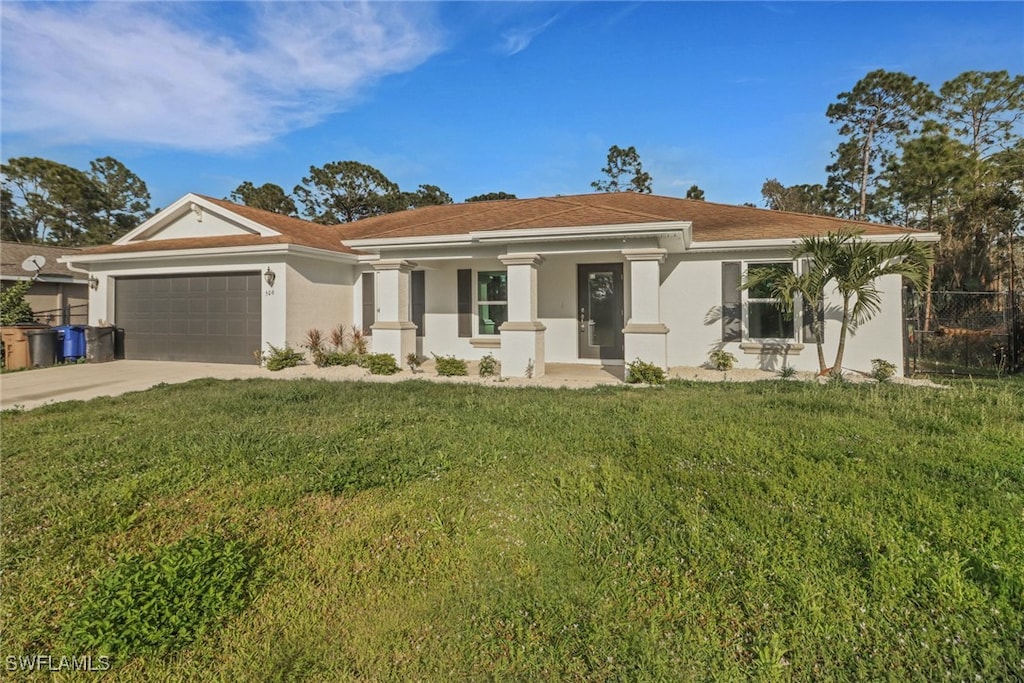 506 Hutton St E, Lehigh Acres, FL 33974 - view of front facade with a garage, stucco siding, driveway, and covered porch