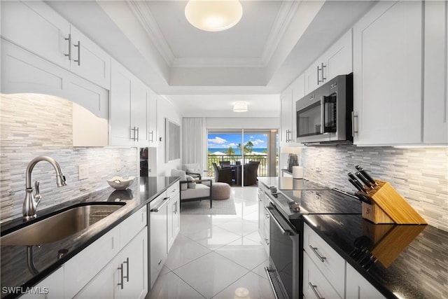 2600 Gulf Shore Blvd N Unit 54, Naples, FL 34103 - kitchen with appliances with stainless steel finishes, a raised ceiling, a sink, tasteful backsplash, and white cabinetry