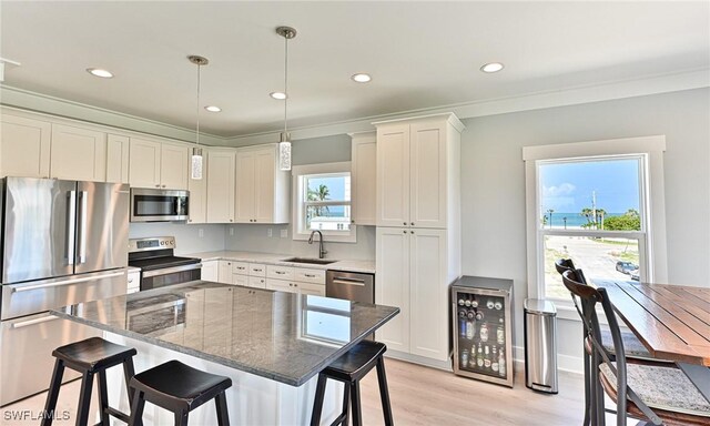 26275 Hickory Blvd Unit 26, Bonita Springs, FL 34134 - kitchen with stainless steel appliances, beverage cooler, a sink, a kitchen bar, and light wood finished floors