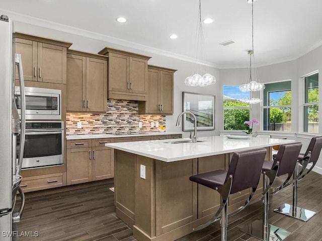 6478 Warwick Ave, Naples, FL 34113 - kitchen with stainless steel appliances, a sink, light countertops, decorative backsplash, and a kitchen breakfast bar