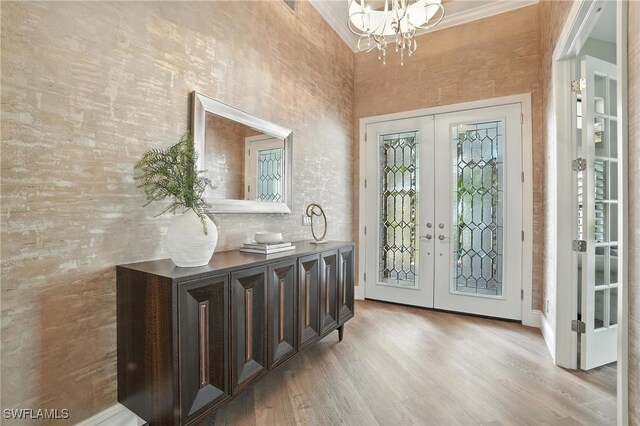 8836 Savona Ct, Naples, FL 34119 - entrance foyer with french doors, a chandelier, and light wood finished floors