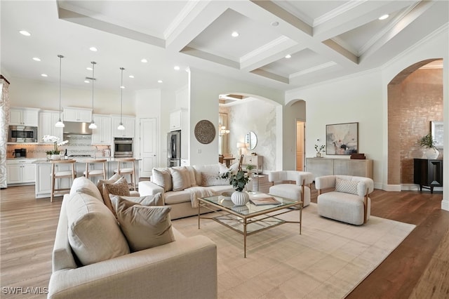 8836 Savona Ct, Naples, FL 34119 - living area with arched walkways, a high ceiling, beamed ceiling, crown molding, and coffered ceiling