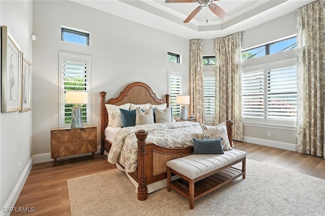 8836 Savona Ct, Naples, FL 34119 - bedroom featuring wood finished floors, multiple windows, a towering ceiling, a raised ceiling, and ornamental molding