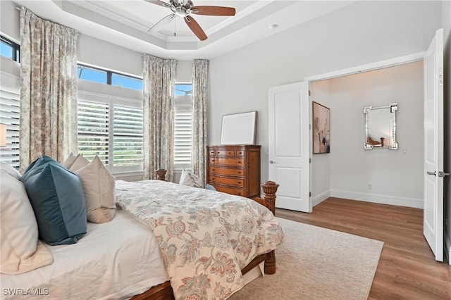 8836 Savona Ct, Naples, FL 34119 - bedroom with wood finished floors, a raised ceiling, and ceiling fan