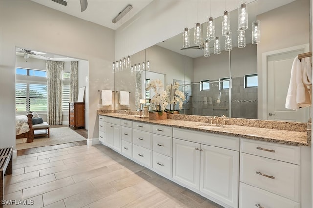 8836 Savona Ct, Naples, FL 34119 - ensuite bathroom with a ceiling fan, double vanity, a shower stall, and a high ceiling