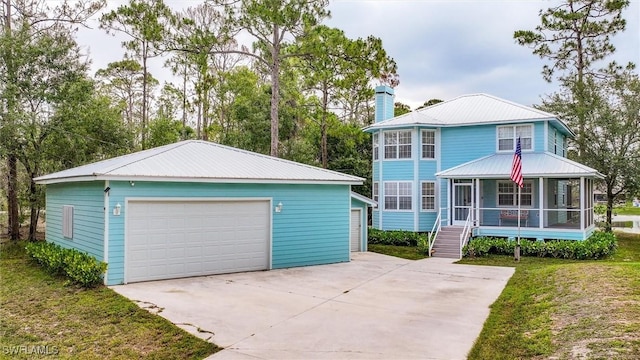 20433 Fern Cir, North Fort Myers, FL 33917 - view of front facade featuring a garage, a chimney, an outdoor structure, a sunroom, and a metal roof