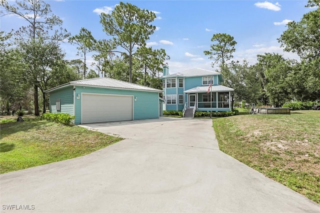 20433 Fern Cir, North Fort Myers, FL 33917 - view of front facade featuring a detached garage, an outbuilding, a sunroom, a metal roof, and a front yard
