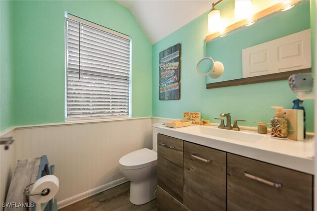 20433 Fern Cir, North Fort Myers, FL 33917 - bathroom featuring wainscoting, vanity, wood finished floors, and lofted ceiling