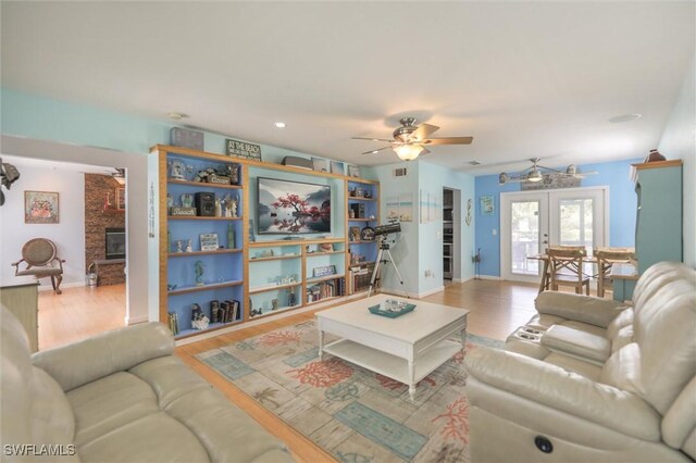 20433 Fern Cir, North Fort Myers, FL 33917 - living room featuring ceiling fan, french doors, wood finished floors, and a fireplace
