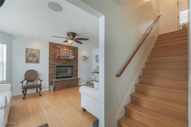 20433 Fern Cir, North Fort Myers, FL 33917 - stairway with ceiling fan, hardwood / wood-style flooring, and a fireplace