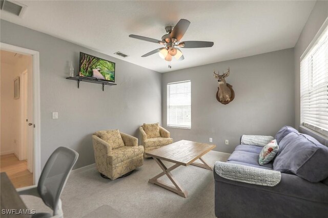 20433 Fern Cir, North Fort Myers, FL 33917 - living area featuring healthy amount of natural light, a ceiling fan, and carpet