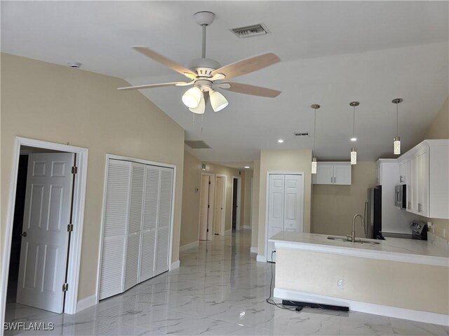 328 Harold Ave S, Lehigh Acres, FL 33973 - kitchen with ceiling fan, a peninsula, light countertops, white cabinets, and stainless steel appliances