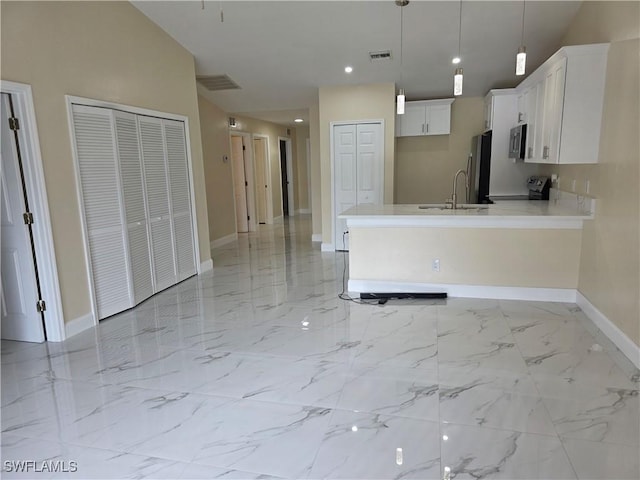 328 Harold Ave S, Lehigh Acres, FL 33973 - kitchen featuring stainless steel microwave, a peninsula, light countertops, stove, and white cabinetry