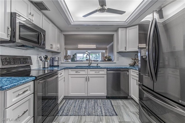 7430 Lake Breeze Dr Unit 403, Fort Myers, FL 33907 - kitchen with appliances with stainless steel finishes, a tray ceiling, a sink, a ceiling fan, and white cabinetry