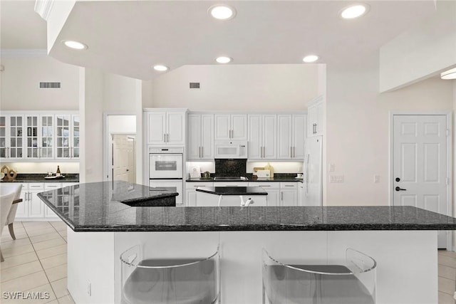 173 Gulfport Ct, Marco Island, FL 34145 - kitchen with white appliances, a large island, light tile patterned floors, recessed lighting, and white cabinets