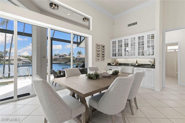 173 Gulfport Ct, Marco Island, FL 34145 - dining room with a water view, ornamental molding, light tile patterned floors, plenty of natural light, and a high ceiling