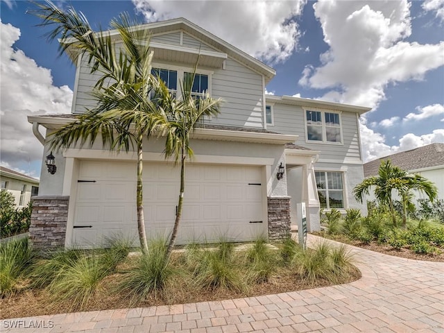 16935 Sage Ter, Punta Gorda, FL 33982 - view of front of house featuring stone siding, driveway, and an attached garage