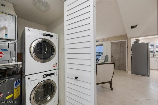 3200 Gulf Shore Blvd N Unit 403, Naples, FL 34103 - laundry room with stacked washer / drying machine, light tile patterned flooring, and electric water heater