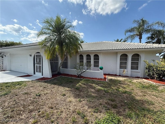 2803 E 5th St, Lehigh Acres, FL 33972 - view of front of home with an attached garage, driveway, stucco siding, a front lawn, and a tile roof