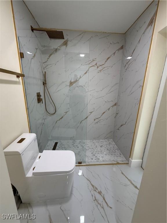 2803 E 5th St, Lehigh Acres, FL 33972 - full bathroom with a marble finish shower, marble tiled floors, and toilet