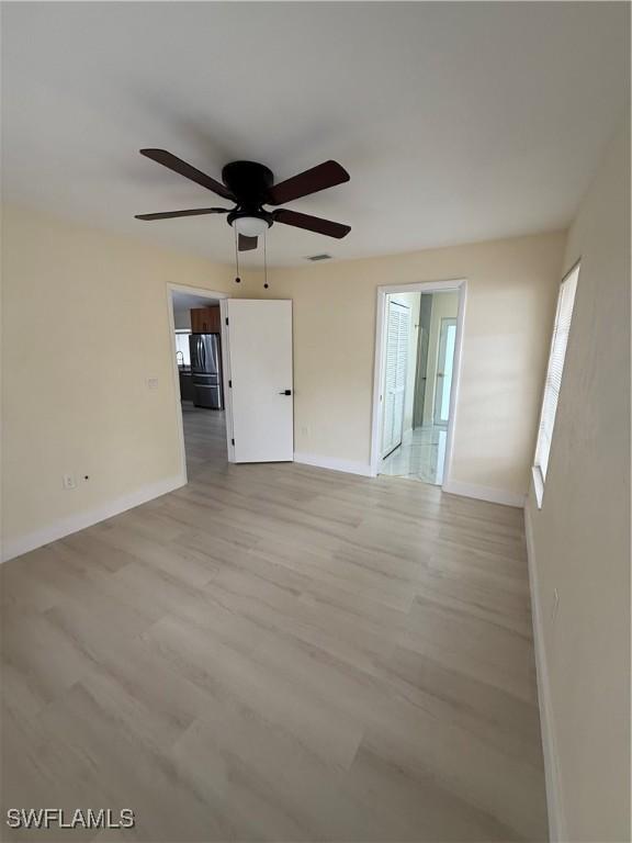 2803 E 5th St, Lehigh Acres, FL 33972 - unfurnished room with baseboards, light wood-style flooring, and a ceiling fan