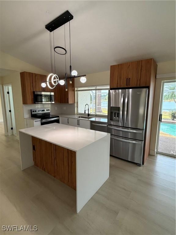 2803 E 5th St, Lehigh Acres, FL 33972 - kitchen featuring stainless steel appliances, modern cabinets, brown cabinets, a sink, and vaulted ceiling