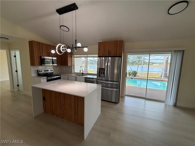 2803 E 5th St, Lehigh Acres, FL 33972 - kitchen with stainless steel appliances, a sink, lofted ceiling, modern cabinets, and brown cabinets
