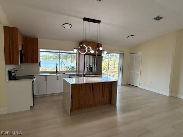 2803 E 5th St, Lehigh Acres, FL 33972 - kitchen with appliances with stainless steel finishes, a sink, light wood-style floors, plenty of natural light, and lofted ceiling
